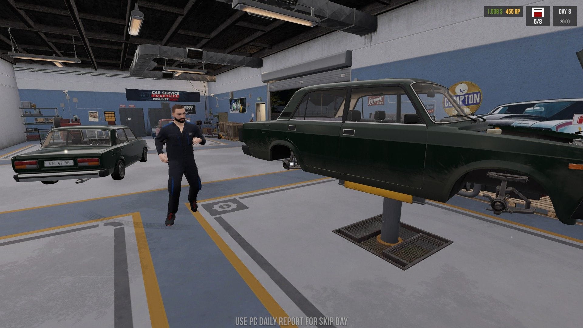 Jonty's character inspecting a green car on a lift with no wheels and few other parts.