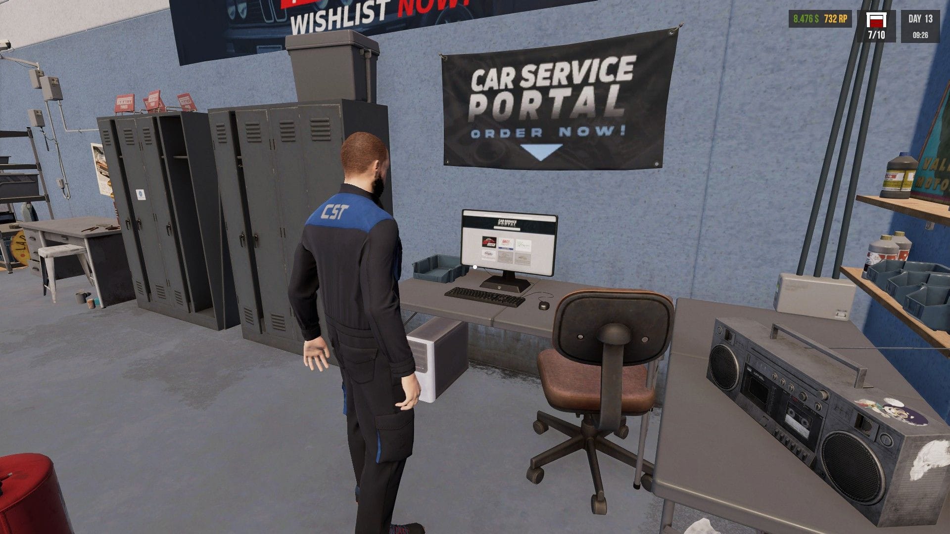 Jonty's character stands in front of a computer and radio on a desk in the garage.