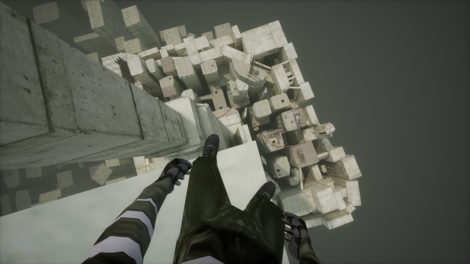 A view of a grey concrete city from far above. The player's feet are visible, standing on a ledge.