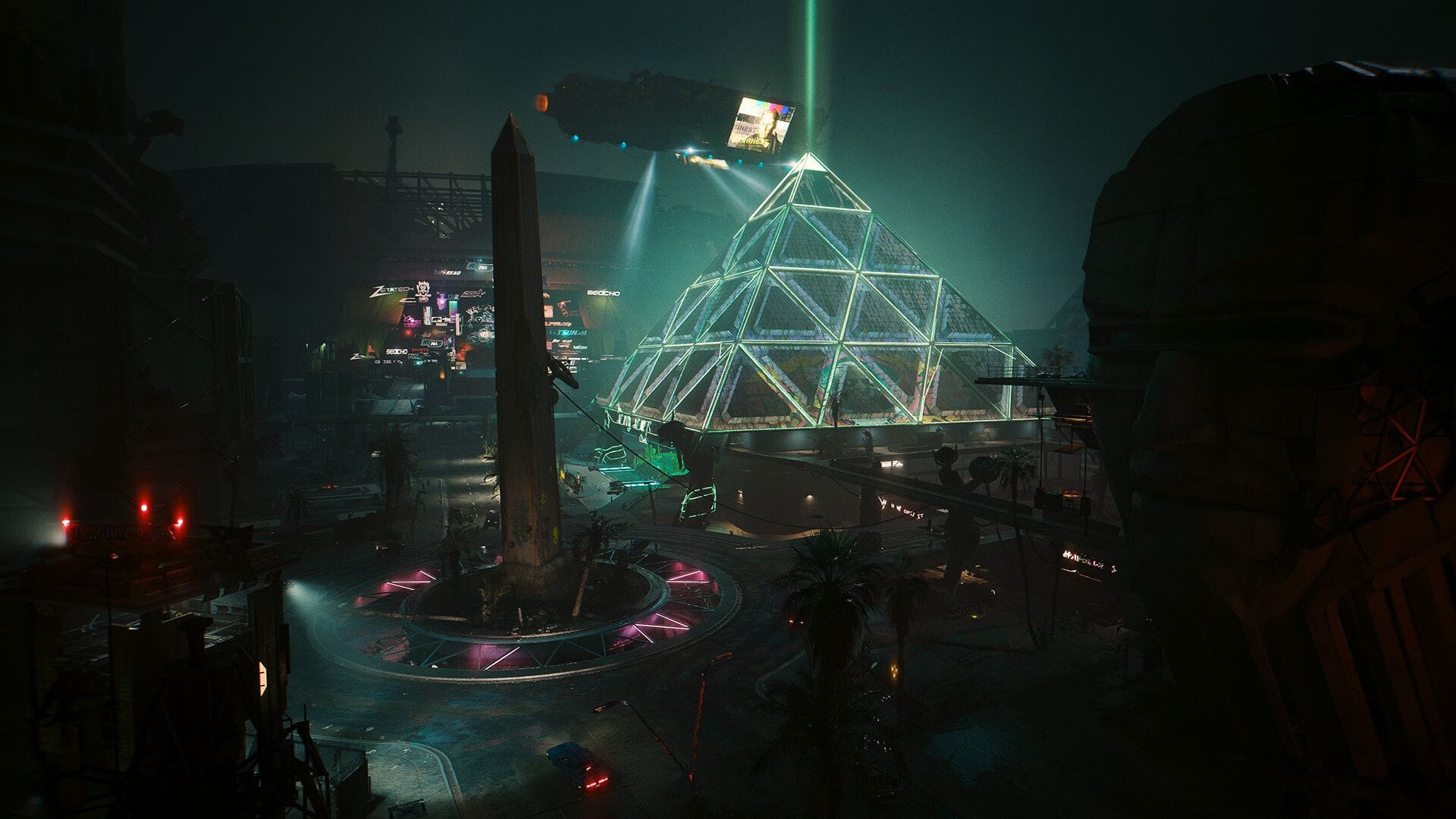 A brightly lit ziggurat at night stands beyond an obelisk surrounded by neon.