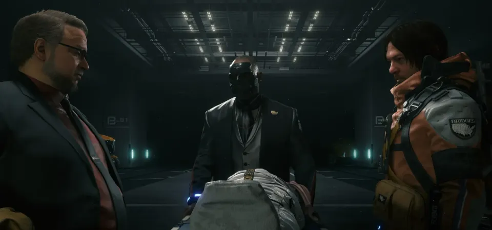 Deadman, Die-Hardman and Sam Porter Bridges stand around the mummified body of Bridget Strand.